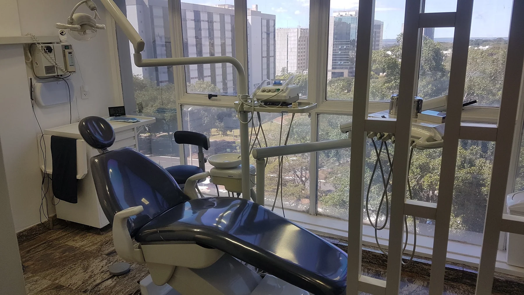 Consultório da CORP com a cadeira odontológica diante da janela