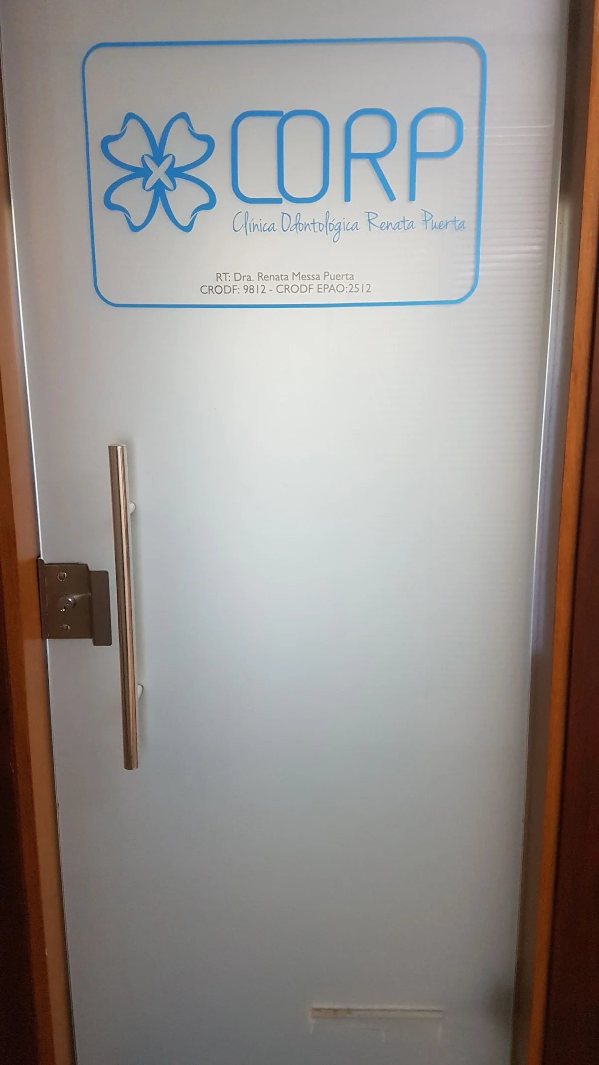 Porta de vidro da CORP, com a marca da clínica e a placa de responsabilidade técnica da Dra. Renata Messa Puerta